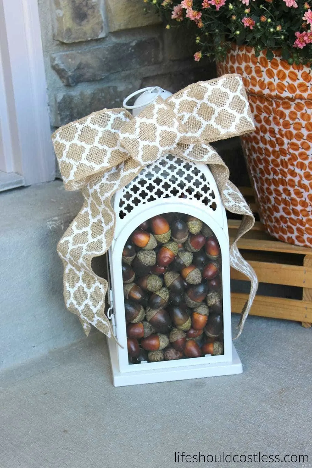Fall lantern filled with acorns. Burlap bow. Rustic/Farmhouse decor idea.